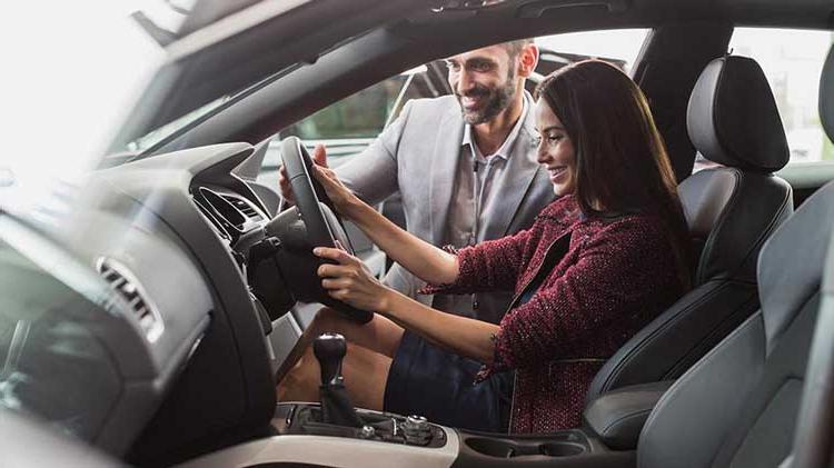 一位年轻女子正在检查一辆新车. 